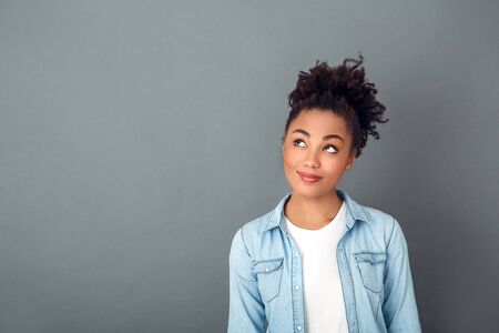 Young african woman isolated on grey wall studio casual daily lifestyle thinking close-upの写真素材