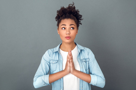 Young african woman isolated on grey wall studio casual daily lifestyle meditatingの写真素材