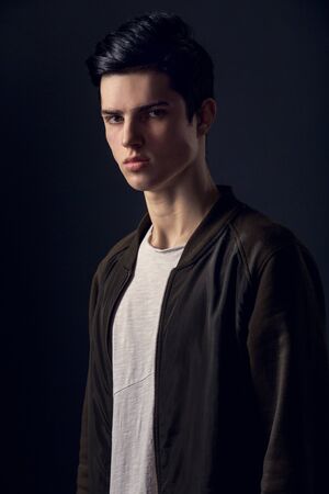 Young man isolated on a grey wall studio concept mysteriousの写真素材