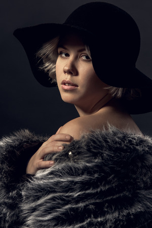 Young woman luxury style isolated on grey wall looking camera close-upの写真素材