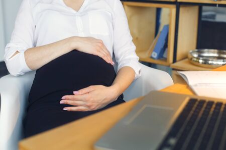 Pregnant business woman working at office motherhood sitting careの写真素材