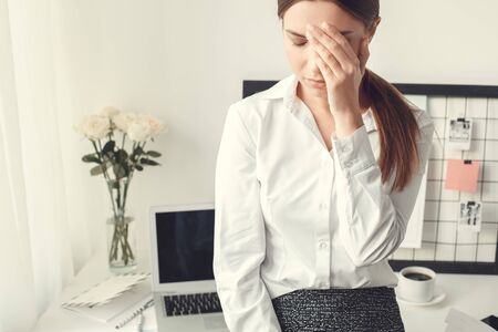 Young woman freelancer indoors home office concept formal style tiredの写真素材