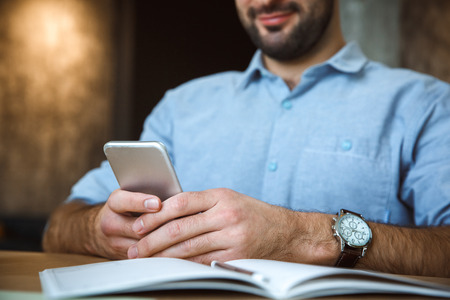 Bachelor man daily routine working from home single lifestyle concept browsing smartphone close-upの写真素材
