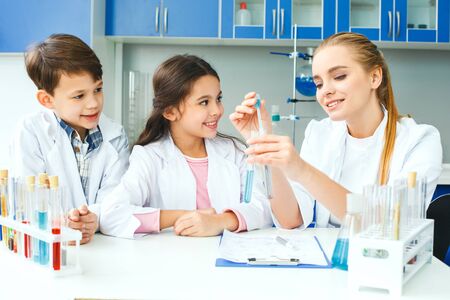 Little kids with teacher in school laboratory explaining reactionの写真素材