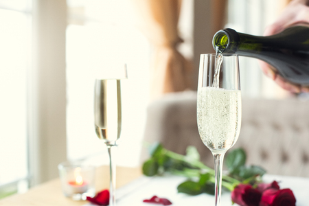 Dining table in restaurant isolated close-up glasses of champagne pouring alcoholの写真素材