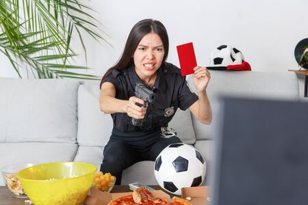 Young woman police officer sport fan watching match irritatedの写真素材