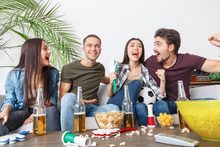 Group of friends sport fans watching soccer match hugging cheerfulの写真素材