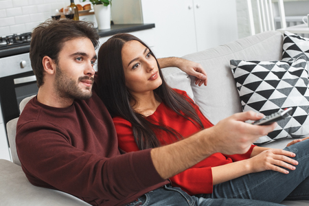 Young couple having romantic evening at home watching movieの写真素材