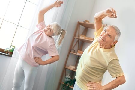 Senior couple exercise together at home health care gymnastic smiling cheerfulの写真素材