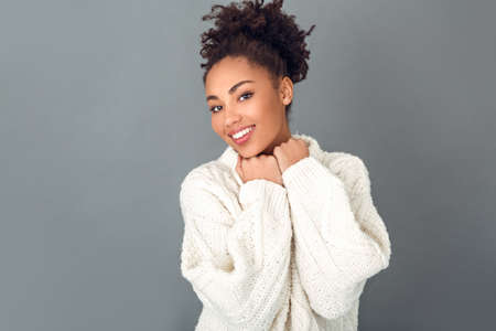 Young african woman isolated on grey wall studio winter concept happinessの写真素材