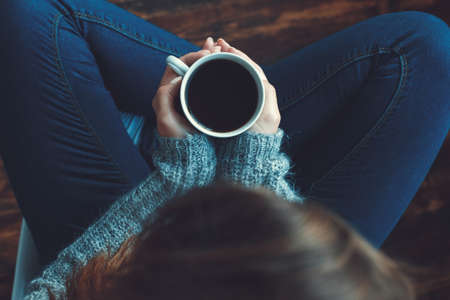 Young woman freelancer indoors home office concept casual style drinking coffeeの写真素材
