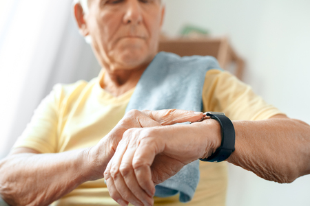 Senior man exercise at home health care measure pulseの写真素材