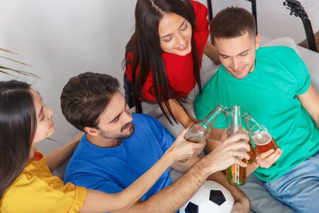 Group of friends sport fans watching match in colorful shirts cheers top viewの写真素材