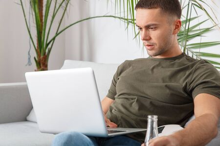 Young man sport fan watching soccer match on laptop close-up concentratedの写真素材