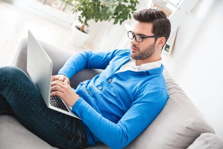 Young man patient waiting psychology session working on laptopの写真素材
