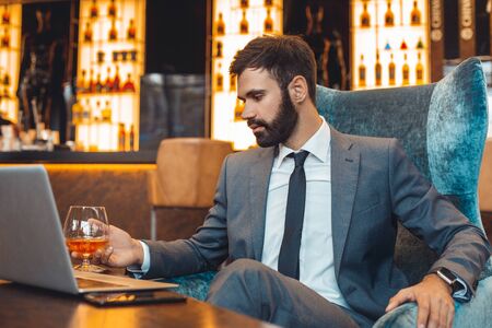 Businessman sitting in a business center bar drinking thinkingの写真素材