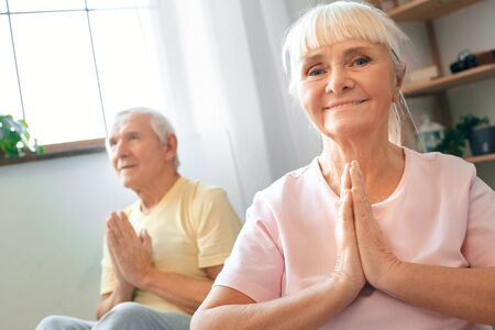 Senior couple doing yoga together at home health care sitting namaskar poseの写真素材