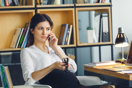 Pregnant business woman working at office motherhood sitting phone conversationの写真素材