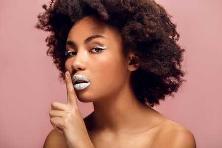 Young african woman isolated on pink wall studio fashion stylish makeup silenceの写真素材
