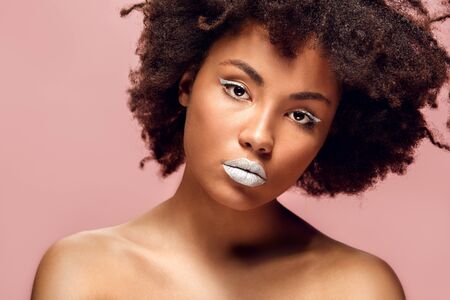 Young african woman isolated on pink wall studio fashion stylish makeup boredの写真素材