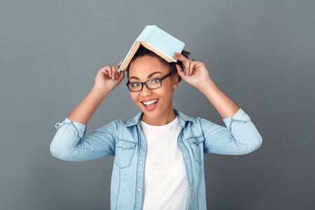 Young african woman isolated on grey wall studio casual daily lifestyle student funの写真素材