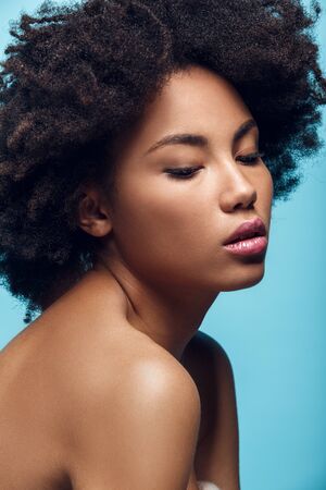 Young african woman isolated on blue wall studio fashion photoshootの写真素材