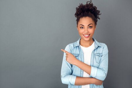Young african woman isolated on grey wall studio casual daily lifestyle copyspaceの写真素材