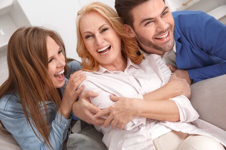 Young family with mother-in-law at home weekend laughing cheerfulの写真素材