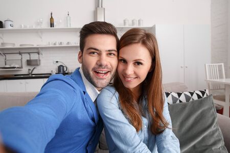 Young couple together at home weekend taking selfie photos cheerfulの写真素材