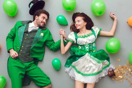 Young couple in festive costumes saint patricks day top view among balloonsの写真素材