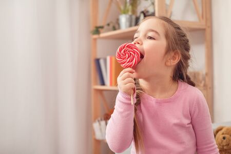 Little cute girl at home celebration concept eating lollipopの写真素材