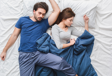 Young couple in bed top view morning concept sleeping relaxedの写真素材