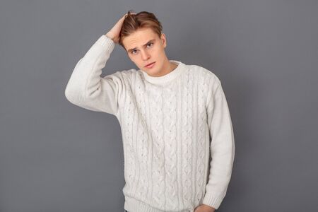 Young man wearing sweater studio isolated on grey handsomeの写真素材