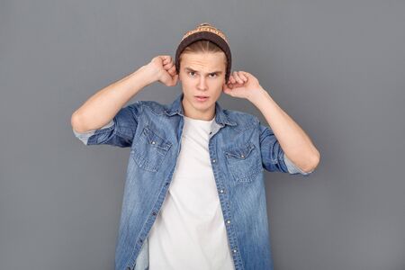 Young man in jeans jacket studio isolated on grey stylish