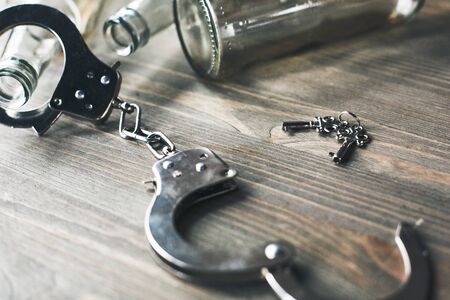 Alcohol addiction objects isolated on table no people opened handcuffs freedom from alcohol close-upの写真素材
