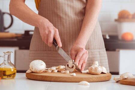 Vegetarian woman cooking veggie dinner, detail, sliced vegetables. Indoor, studio shoot, kitchen interiorの写真素材