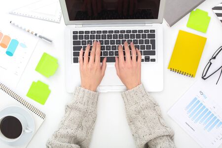 Young woman sitting at the table top view close-up typing on laptop mail business correspondenceの写真素材