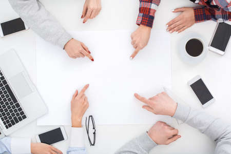 Group of men and women work together top view close-up pointing at center copyspaceの写真素材