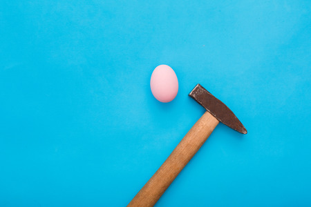 Easter traditional objects isolated on blue background egg and hammerの写真素材