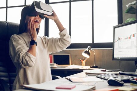 Woman first in virtual reality. New better model virtual glasses. Indoor, studio shot. Business people concept, work in officeの写真素材