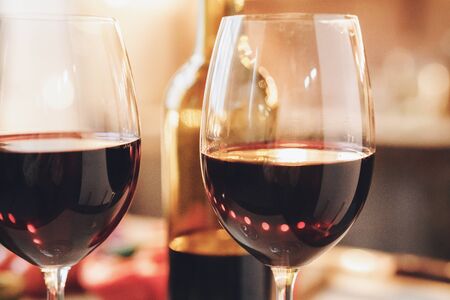 Closeup picture of two elegant glasses of red wine. Indoor, kitchen home interior, studio shot.の写真素材
