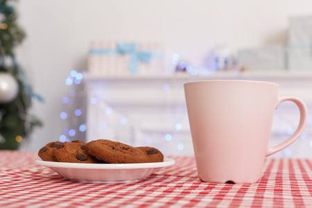 Merry Christmas. Decorated room no people cup of milk and cookies on table close-upの写真素材