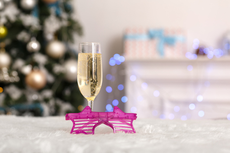 New Year. Decorated room no people glass of champagne and fancy glasses close-up blurred backgroundの写真素材