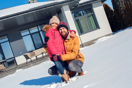 Winter vacation. Family time together outdoors father hugging daughter smiling cheerfulの写真素材