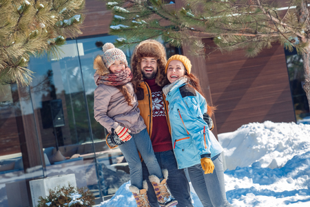Winter vacation. Family time together outdoors father holding daughter up laughing happyの写真素材