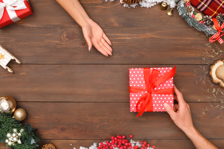 New Year. Man giving present to woman isolated on decorated table top view close-upの写真素材