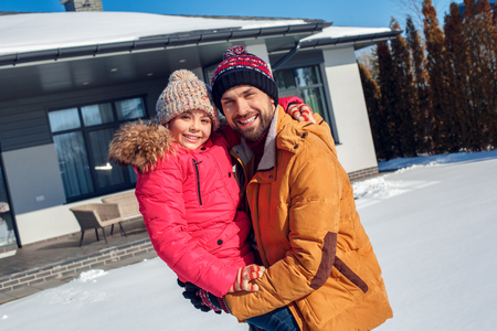 Winter vacation. Family time together outdoors father holding daughter smiling happy close-upの写真素材