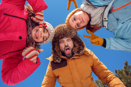 Winter vacation. Family time together outdoors grimacing to camera playful bottom viewの写真素材