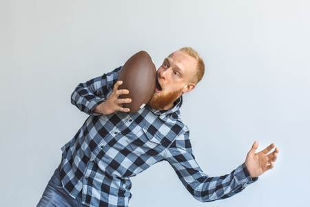 Freestyle. Mature man bending aside isolated on grey got face hit with ball unexpectedの写真素材