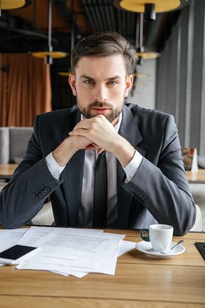 Businessperson on business lunch at restaurant sitting looking camera thoughtfulの写真素材